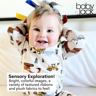 Baby with multi-colored bow highlighting soft plush textures and sensory ribbon variety