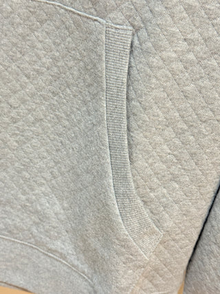 Close-up of gray quilted hoodie fabric showing ribbed seam detail