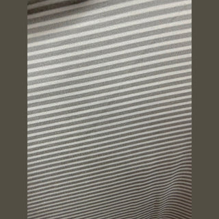 Close-up texture of light gray off-white micro-feeder stripe performance knit fabric