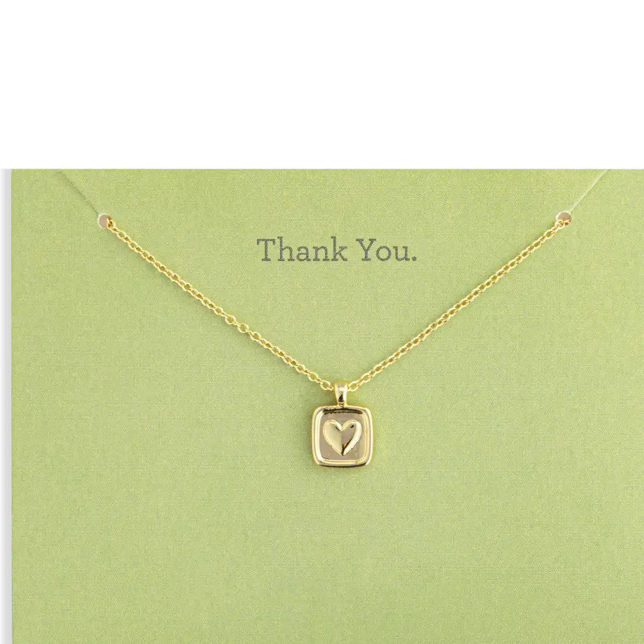 Gold necklace with a heart pendant on a green card that says 'Thank You'.