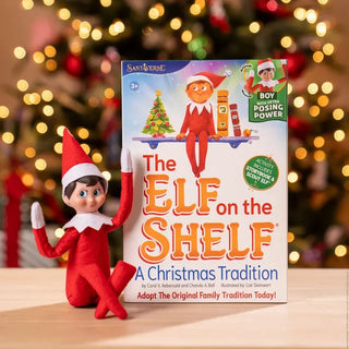 Elf on the Shelf poseable boy elf doll in red suit beside product box