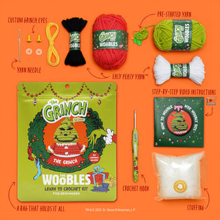 The Woobles Grinch crochet kit for beginners showing all included materials on orange background