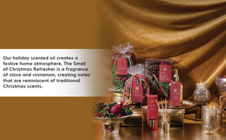 Aromatique The Smell of Christmas holiday scented oil collection displayed with festive decorations on golden backdrop