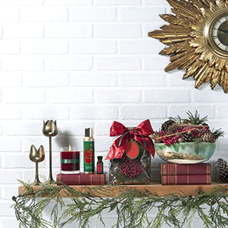 Aromatique The Smell of Christmas refresher oil displayed in festive holiday shelf arrangement with candle and greenery