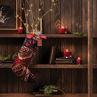 Aromatique The Smell of Christmas refresher oil displayed in decorative stocking with holiday candles on wooden bookshelf