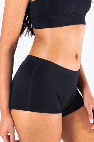 Black modal boyshort underwear with matching black sports bra on female model