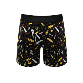 Back view of black boxer briefs with colorful hammer and tools pattern on white background