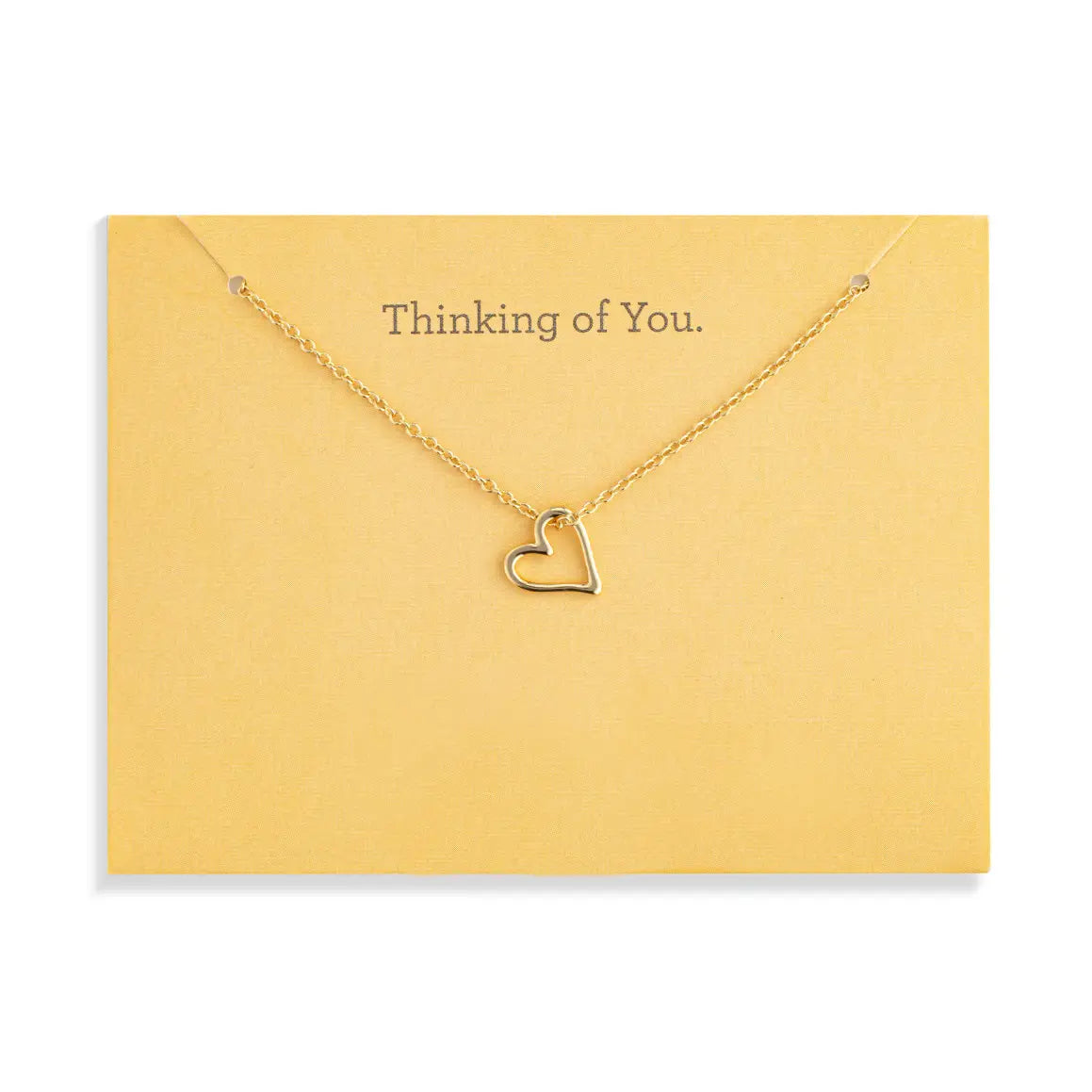 Gold heart necklace on a yellow card with 'Thinking of You' text