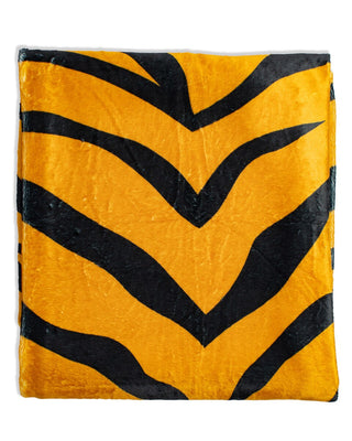 Plush throw blanket with bold orange and black tiger stripe pattern