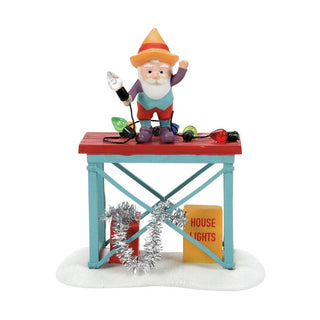 Department 56 gnome figurine decorating table with Christmas lights on red and teal stand