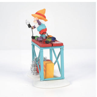 Department 56 Time to Decorate figurine showing elf decorating Christmas lights on blue table