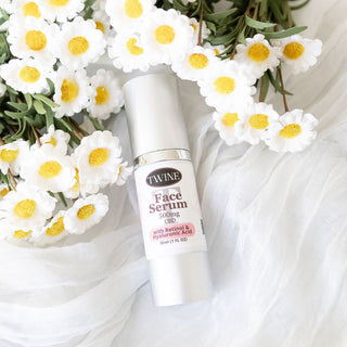 Twine 500mg CBD Face Serum flat lay with fresh white daisies and sheer fabric