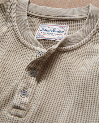 Close-up detail of Flag & Anthem tan waffle-knit henley showing buttons and brand label