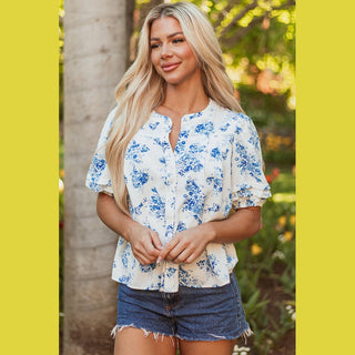 Viola blue floral blouse with tiered puff sleeves and pleated button front on model