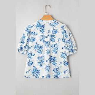 Back view of Viola blue floral blouse hanging showing central pleat and sleeve detail