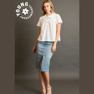 Woman wearing a white blouse and denim skirt with 'Young Contemporary' logo.