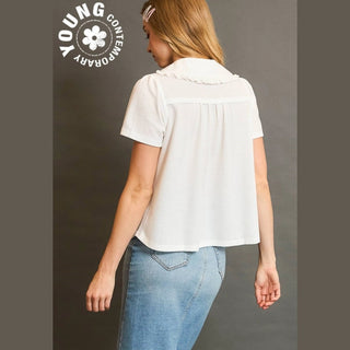 Woman wearing a white blouse and blue jeans with 'Young Contemporary' logo.