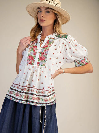 Woman wearing a floral blouse and straw hat 