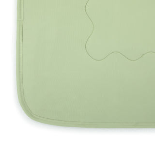 Close-up detail of sage green weighted cooling lap blanket showing stitched wavy pattern and bound edge
