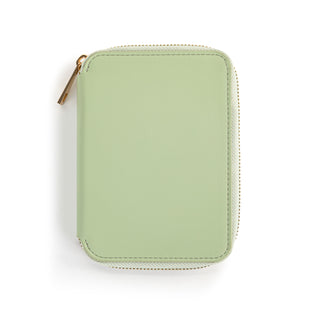 Sage green zip-around passport wallet with gold zipper hardware on white background