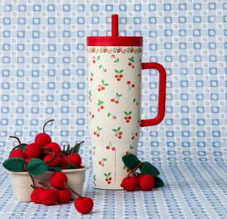 Tumbler with cherry design and red handle on a blue checkered background