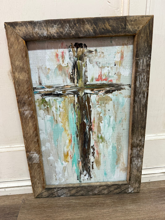 Abstract cross painting in a rustic wooden frame .