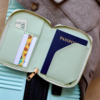 Open sage green RFID passport wallet showing card slots, cash pocket, and passport compartment