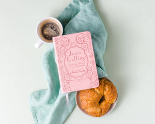 Jesus Calling pink leathersoft devotional book by Sarah Young styled with coffee and croissants
