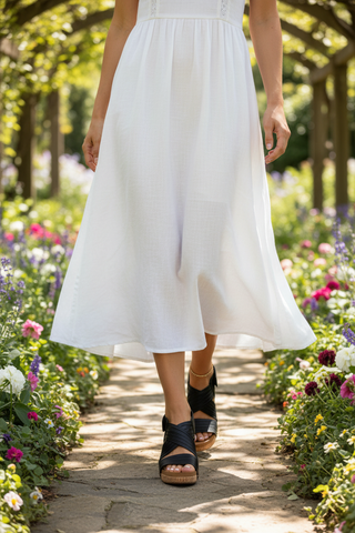 Woman wearing black wedge sandals with white midi dress
