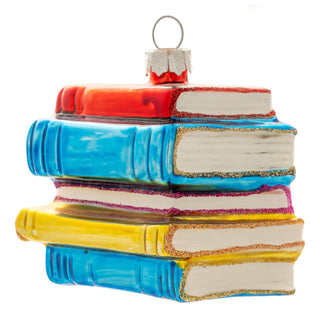 Karma glass ornament shaped as stacked red, blue, and yellow books with glitter trim