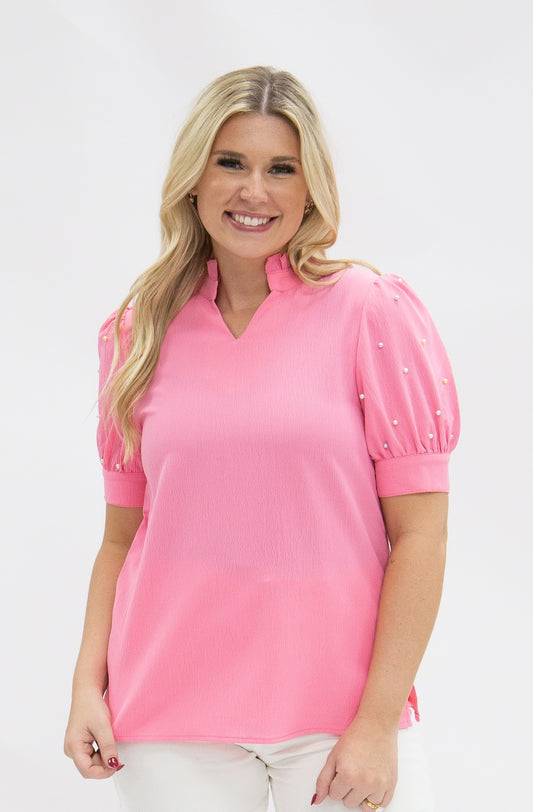 Pink short sleeve top with pearl on the puff sleeve. 