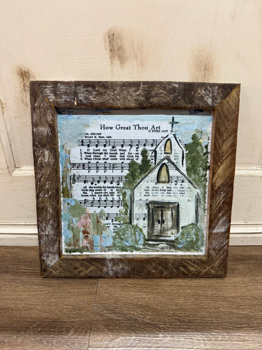 Framed artwork with a church illustration and sheet music.