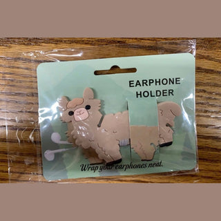 Llama earphone holder in light beige with black feet, pink snout and fluffy textured fur, packaged on mint-green card with white earphones wrapped around