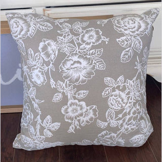 Grey linen floral print pillow with white roses and leaves on dark wood