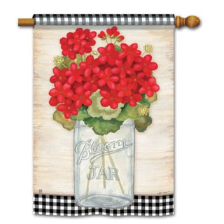 Red Geranium blooms in mason jar garden flag with gingham border on wooden pole