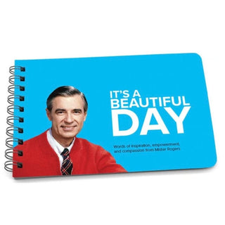 Closed sky blue cover of It's a Beautiful Day book featuring Fred Rogers portrait and red cardigan with spiral binding