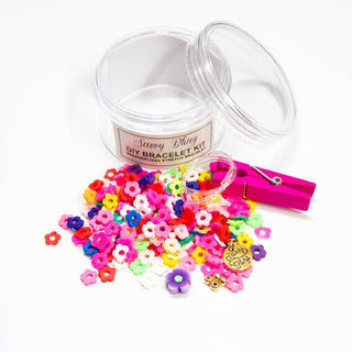Flower-shaped bead bracelet kit in vibrant pink and red with textured petal edges and fuchsia wooden clothespin