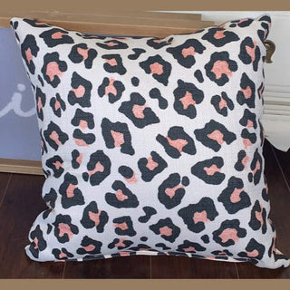 Cream leopard print pillow with black and dusty rose rosettes on textured polyester fabric