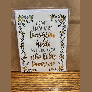 Floral vine tomorrow holds card with gold foil script and black sans-serif text
