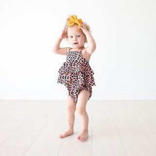 Toddler girl wearing pink leopard print bubble romper showing airy fit and ruffled tiered design