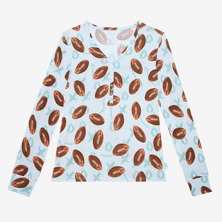 Close-up of light blue V-neck henley pajama top with brown football print and three-snap nursing placket