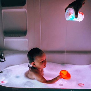 Child playing with water-activated glowing purple bath cubes in bubbly tub