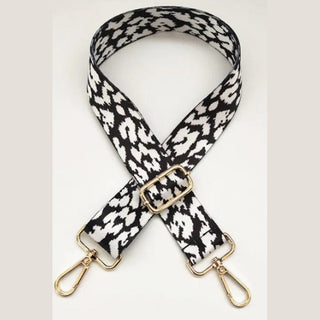 Black and white monochrome leopard pattern purse strap on gray background