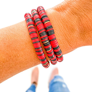 Red and black heishi bracelet with gold spacers, flat disc beads on wrist for casual everyday wear
