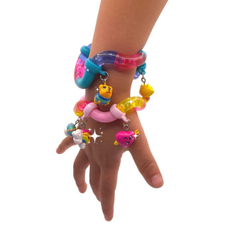 Child wearing layered Tangle Charms bracelets with translucent blue purple core and cat bird heart charms