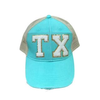 Turquoise trucker hat with beige mesh back and white fuzzy TX lettering